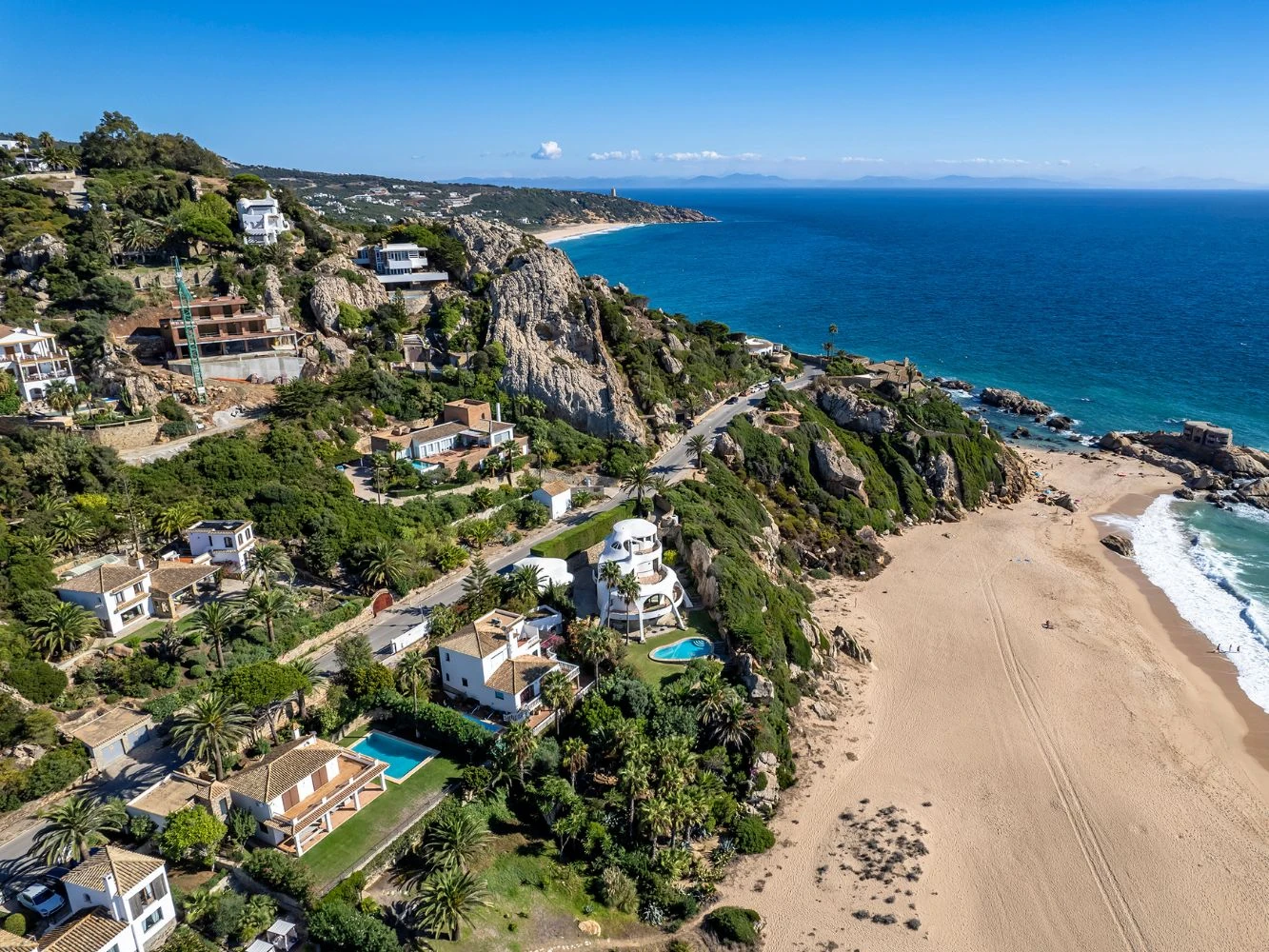 Aerial view of Atlanterra: villas above a golden beach and the Atlantic, Costa de la Luz